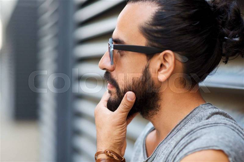 Lifestyle, emotion, expression and people concept - happy smiling man with sunglasses and beard on city street, stock photo