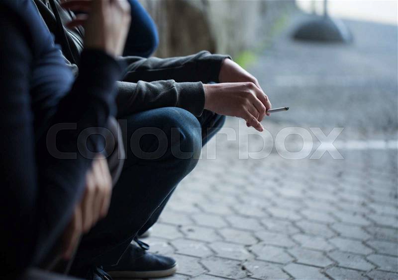 Substance abuse, addiction, people and bad habits concept - close up of young men smoking cigarettes outdoors, stock photo