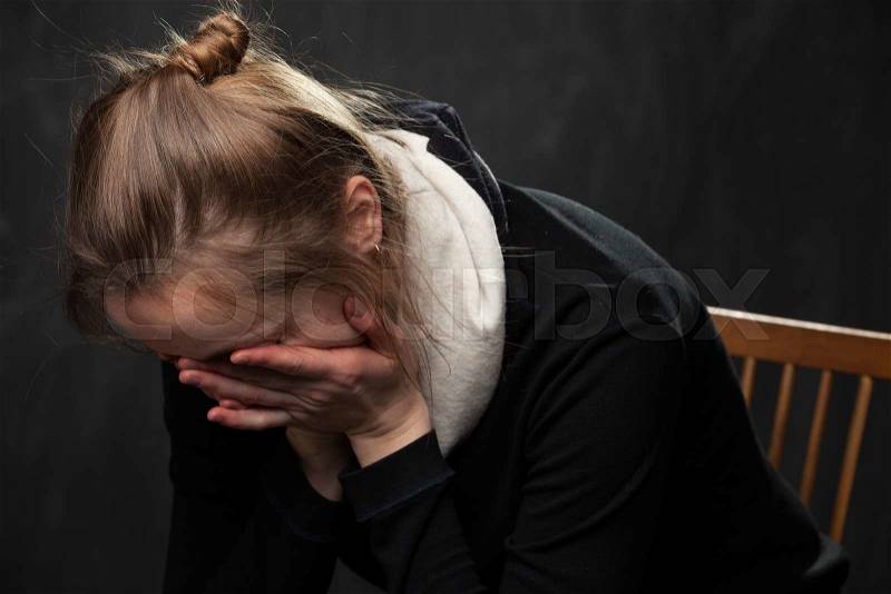 Crying woman . Her face is hidden in her arms, stock photo