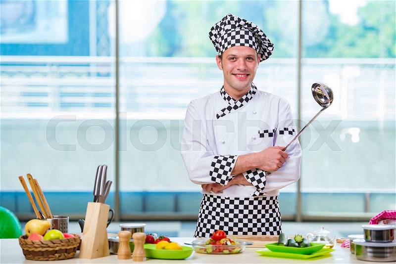 Male cook preparing food in the kitchen, stock photo