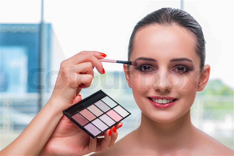 Beautiful woman during make-up cosmetics session, stock photo
