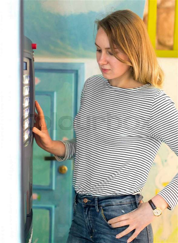 Pretty woman using coffee vending machine, stock photo