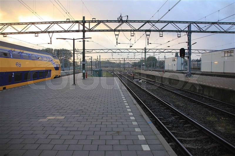 The train is leaving the railway station in the city The Hague at sunrise in the summer, stock photo
