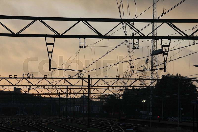 Overhead lines for the transportation of the trains at the railway station in the city The Hague at sunrise in the summer, stock photo