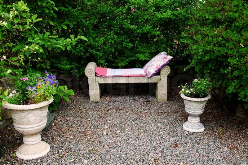 A garden bench with a blanket and pillow, stock photo