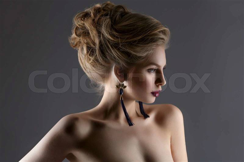 Beautiful young woman with long neck wearing earrings. Beauty shot, stock photo