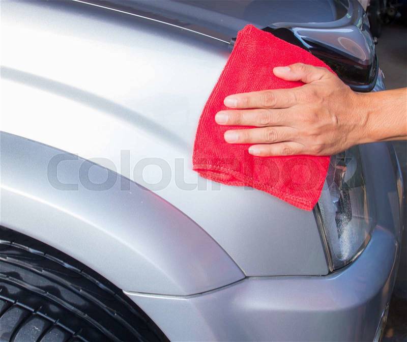 Hand with microfiber cloth cleaning a car, stock photo