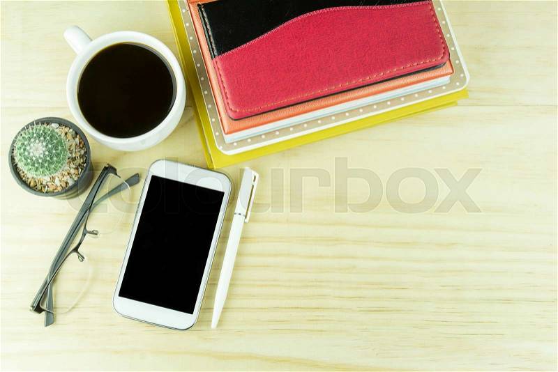 Smart phone,coffee cup,glasses, cactus and note book on wooden table background. Business concept, stock photo