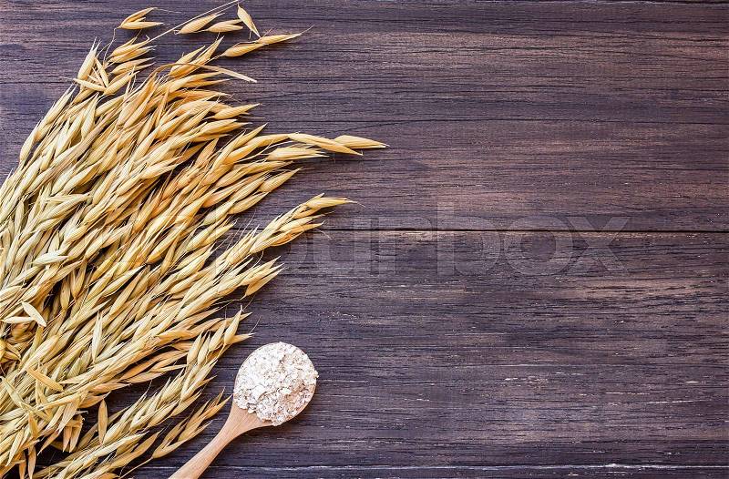 Rolled oats and oat ears of grain on a wooden table.ears of wheat on the table. top view with copy space, stock photo
