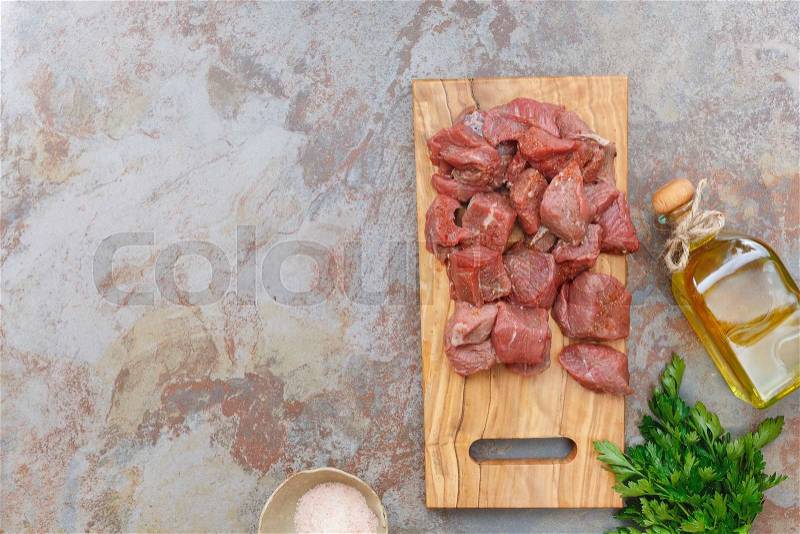 Meat cubes. Seasoned raw meat ready to be cooked, Top view, blank space on the left side, stock photo