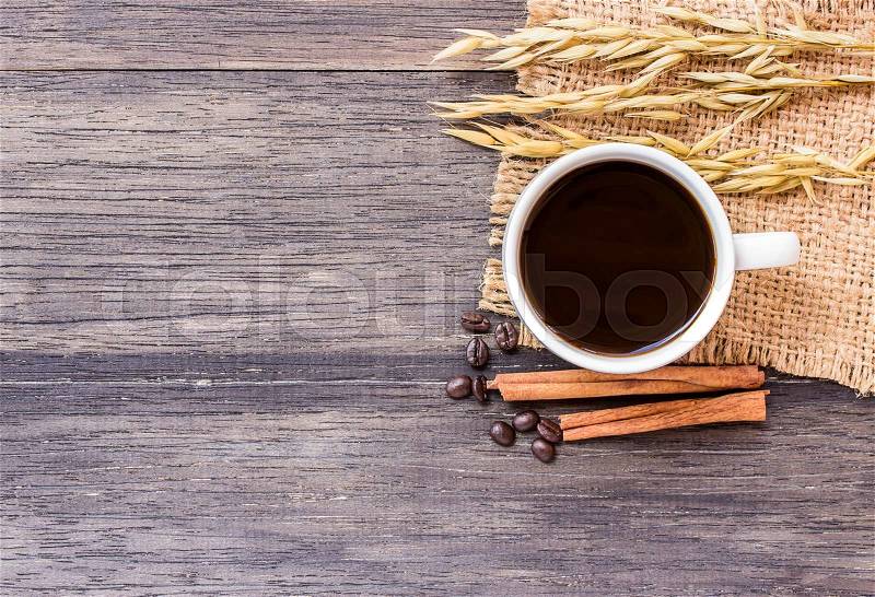 Cup of coffee and ears of oat on dark wooden table background. top view with copy space, stock photo
