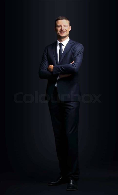 Handsome business man smiling on black background, stock photo