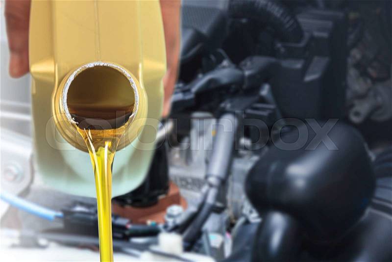 Motor oil pouring, Pouring oil lubricant motor car from bottle, stock photo