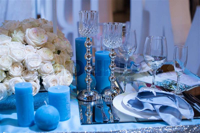 Wedding decor in blue. candles and flowers on the table, stock photo