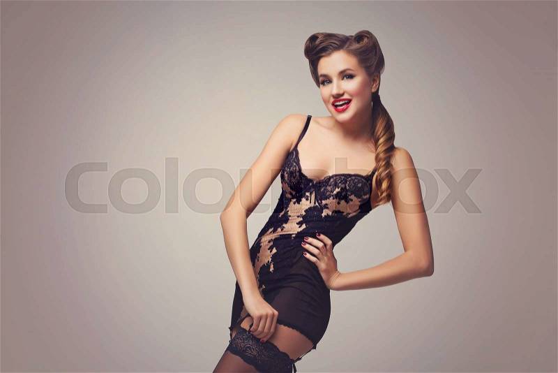 Beautiful retro pinup girl with red lips in black lace lingerie. Studio shot. Copy space, stock photo