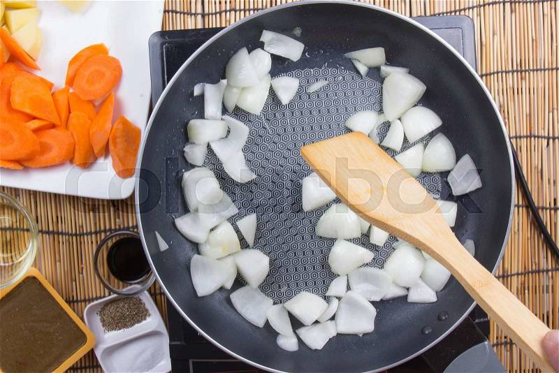 Chef stir-fried slice of onion in the pan for cooking Japanese pork curry / cooking Japanese pork curry concept, stock photo