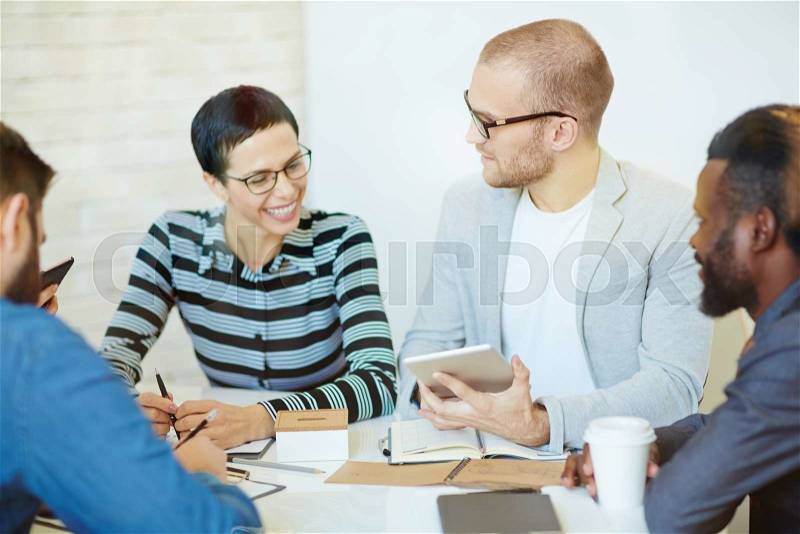 Successful men and woman having business conversation in office, stock photo