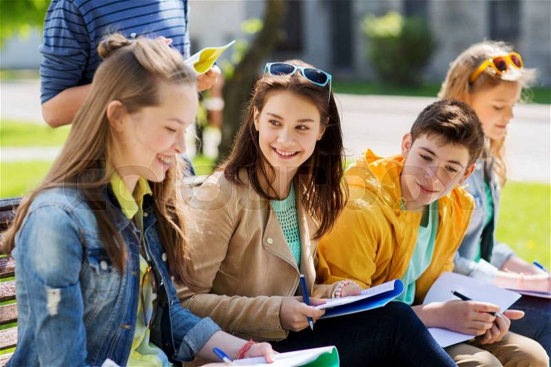 Education, high school and people concept - group of happy teenage students with notebooks learning at campus yard, stock photo