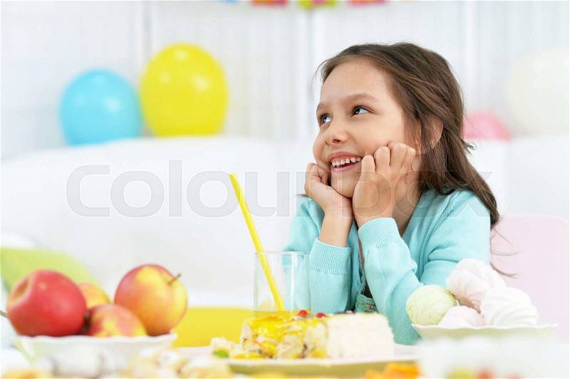 Happy little girl with cake at birthday party, stock photo