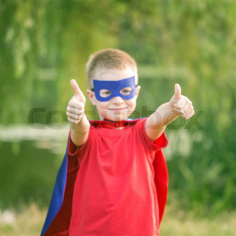 Kid in super hero costume showing thumbs up. Selective focus on thumbs up. The winner and success concept. , stock photo