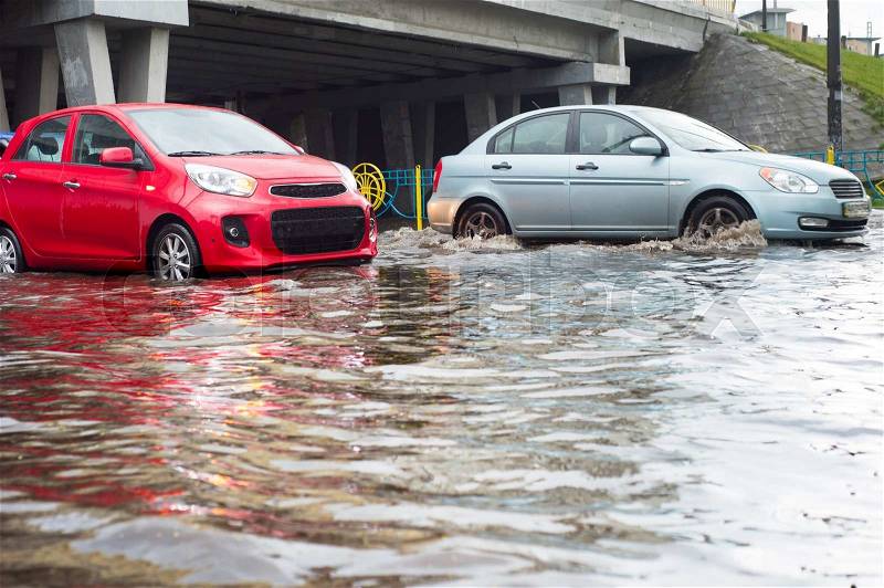 Cars on a flooded city road during the rain, stock photo