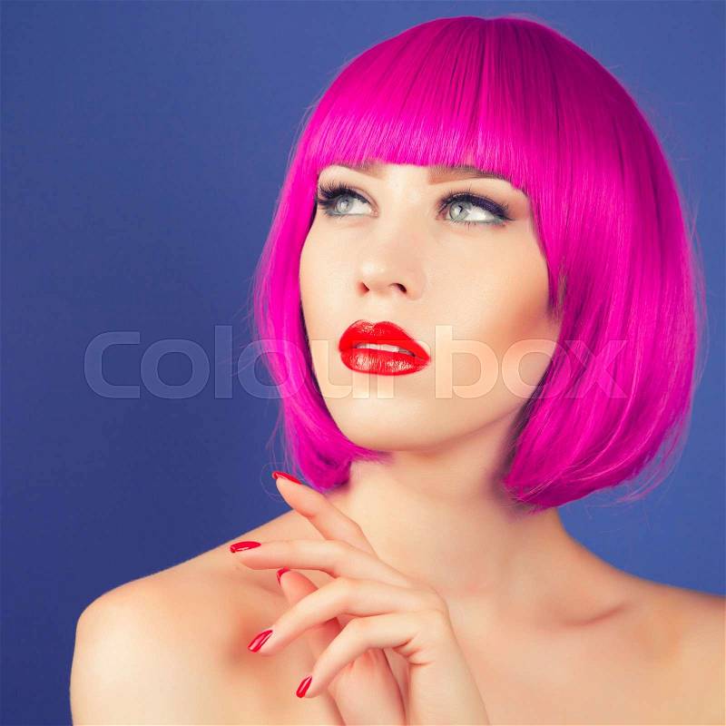 Beautiful woman wearing colorful wig against blue background, stock photo