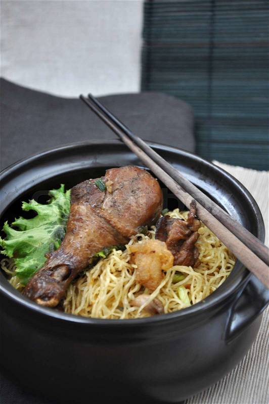 Black bowl of chicken noodle with wooden chopsticks, stock photo