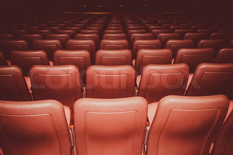 Movie theatre seats in red colors in a dark room, stock photo