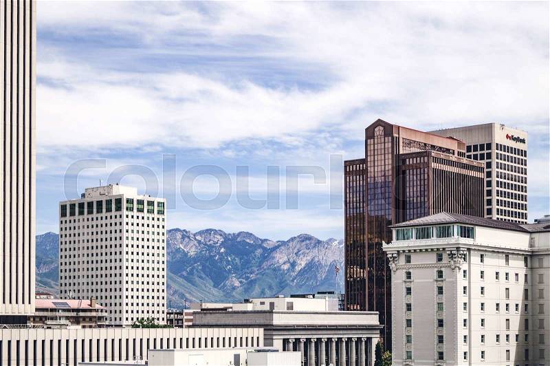 Large buildings in an american city with mountains in the background, stock photo