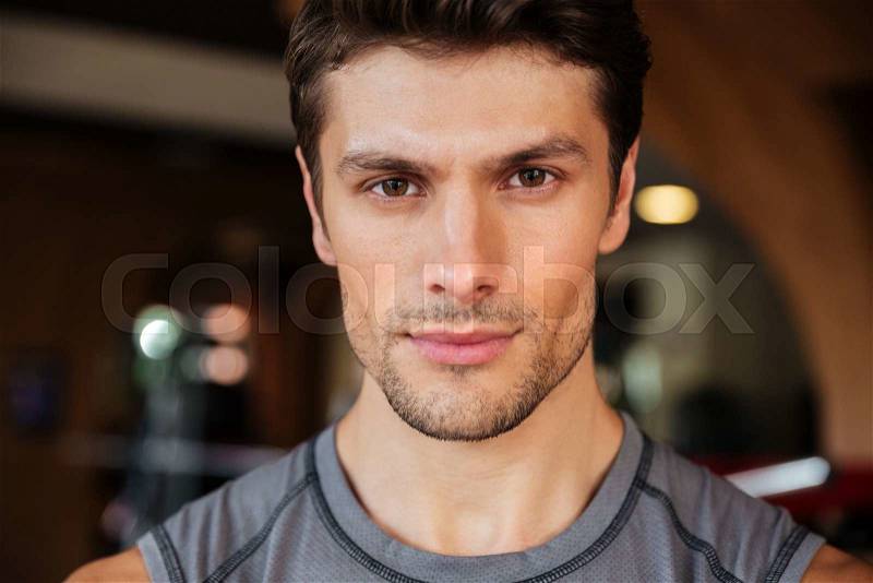 Closeup of handsome young fitness man in gym, stock photo