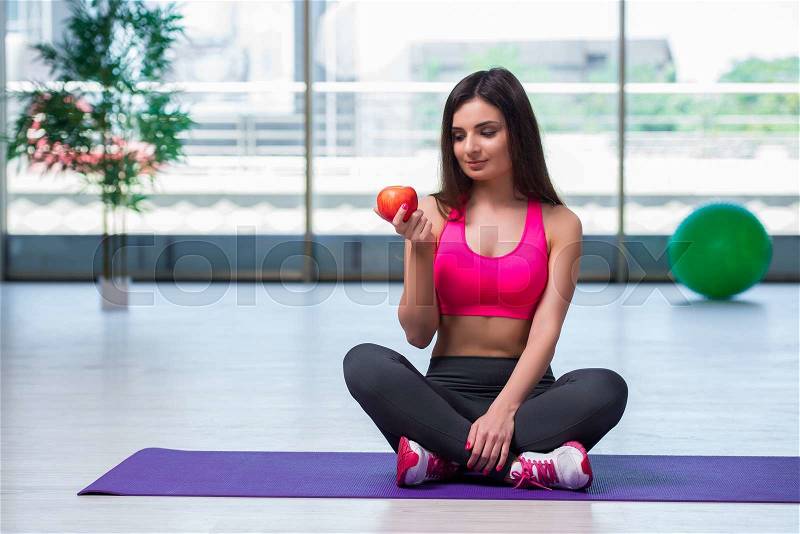Young woman eating red apple in health concept, stock photo