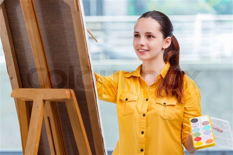 Young student artist drawing pictures in studio, stock photo