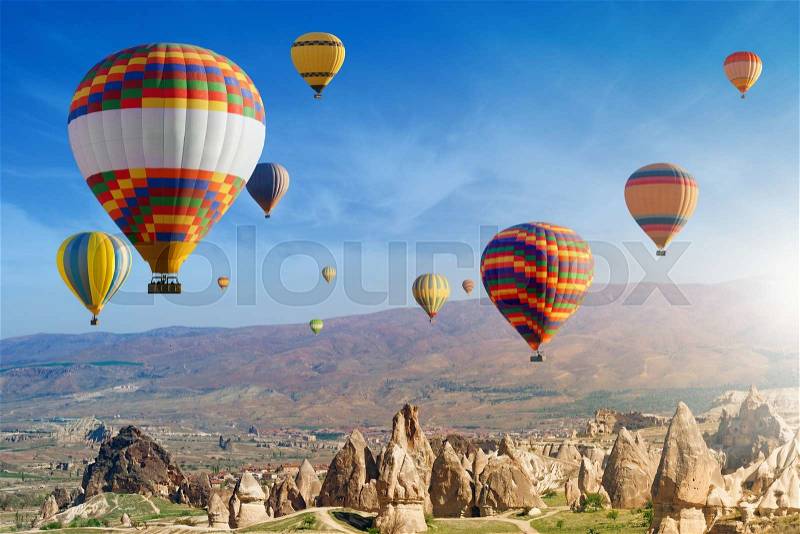 Hot air ballooning is most amazing attraction and adventure in Kapadokya. Colorful hot air balloons flies in morning above unusual rocky landscape in Cappadocia, Turkey, stock photo
