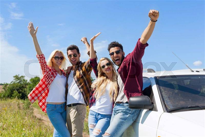 People group outdoor countryside excited raise arms friends smile holding hands up near car summer day trip, stock photo
