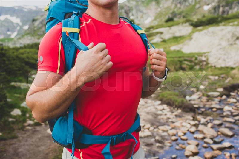 Hiking man portrait with backpack walking in nature. Caucasian man holding hands on backpack, hiking near the river, stock photo
