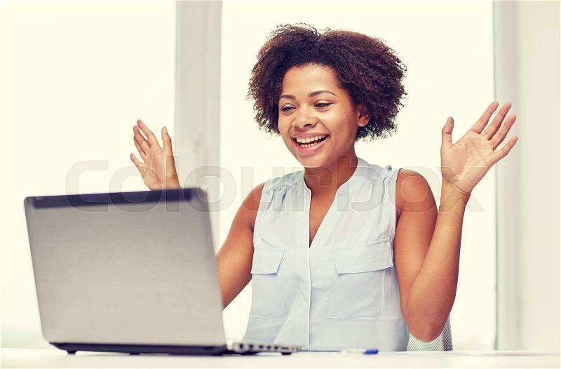 Education, business, success and technology concept - happy african american businesswoman or student with laptop computer and papers at office, stock photo