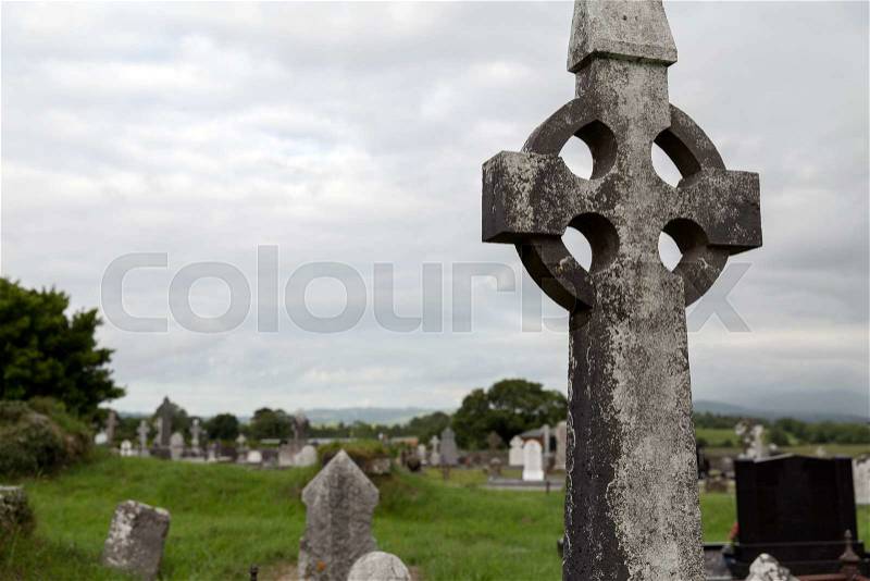Ancient monument and burial concept - old grave cross, headstones and ruins on celtic cemetery graveyard in ireland, stock photo