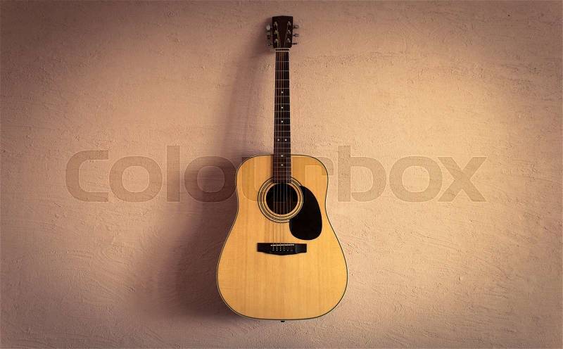 Acoustic guitar on beige background vintage wall, stock photo
