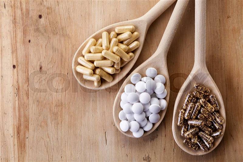Wooden spoons of various dietary supplements on wooden background, stock photo