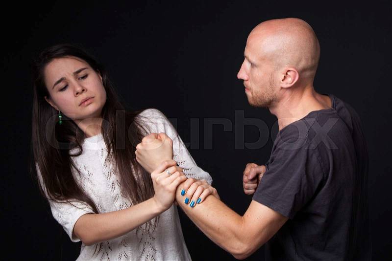 Domestic violence - husband and wife are fighting, woman getting hold of man\'s fist, stock photo