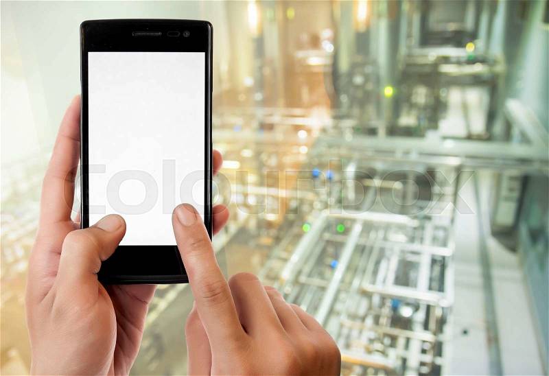 Hand holding smart phone on Manufacturing factory blurred background, stock photo