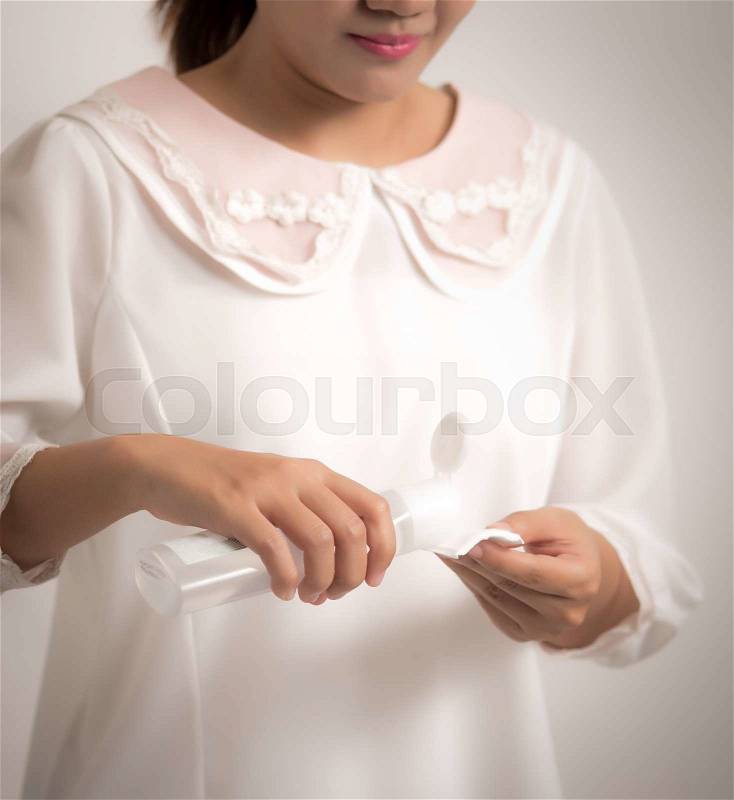 Woman using cleaning lotion make-up remover, stock photo