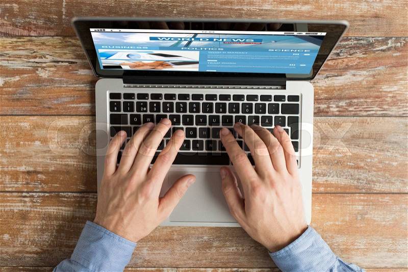 Business, mass media, people and technology concept - close up of male hands typing on laptop with news web site on screen, stock photo