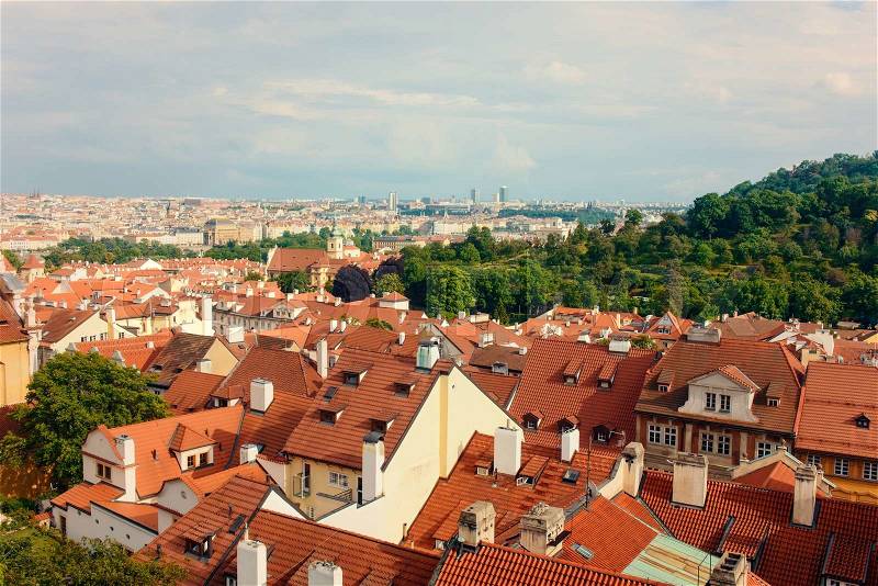 Birds eye view on tiled roofs on various white and yellow stucco townhouses in Prague, stock photo