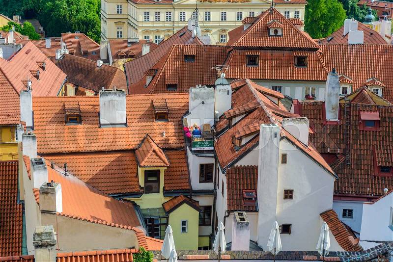 Birds eye view on tiled roofs on various white and yellow stucco townhouses in Prague, stock photo