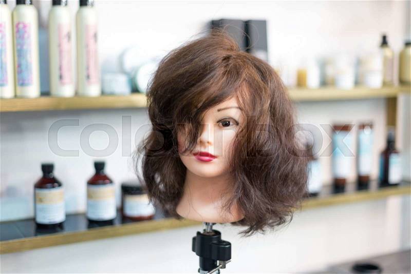 Hairdressing woman training head in beauty salon, stock photo