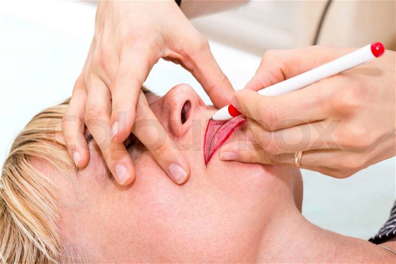 Lip tattoo woman in a beauty salon process, stock photo