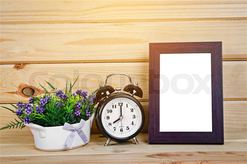 Blank wood photo frame and alarm clock with flower on wooden room, Save clipping path, stock photo