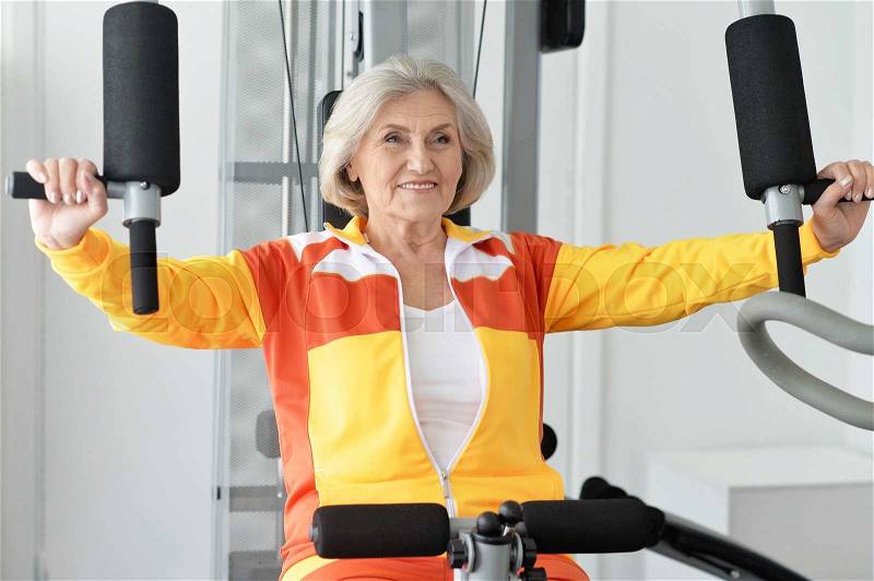 Portrait of elderly woman exercising in gym, stock photo
