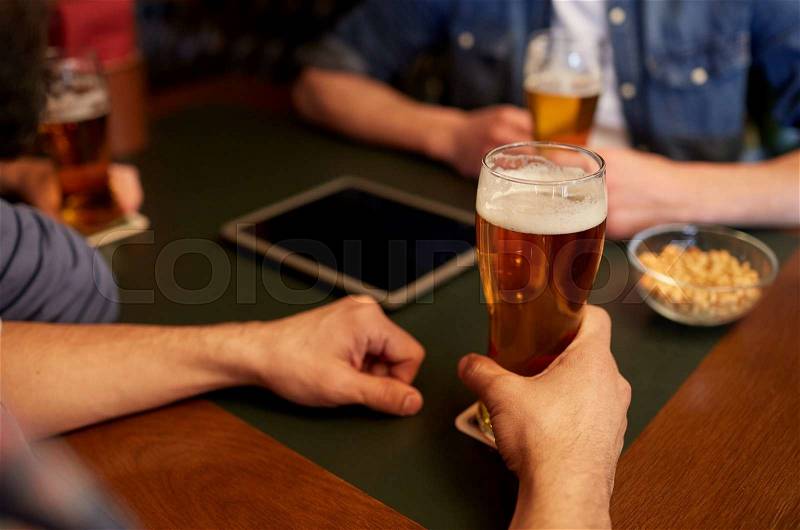 People, men, leisure, friendship and communication concept - close up of male friends drinking draft beer at bar or pub, stock photo